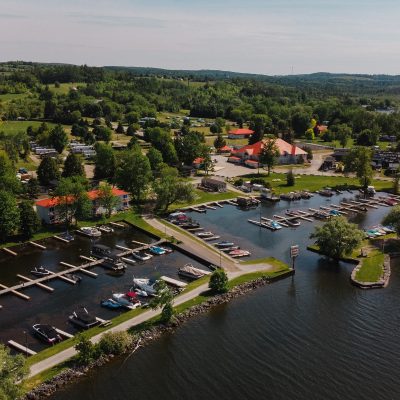 Aerial view of Golden Beach Resort in The Kawarthas from the lake facing the resort showing a marina with boats.